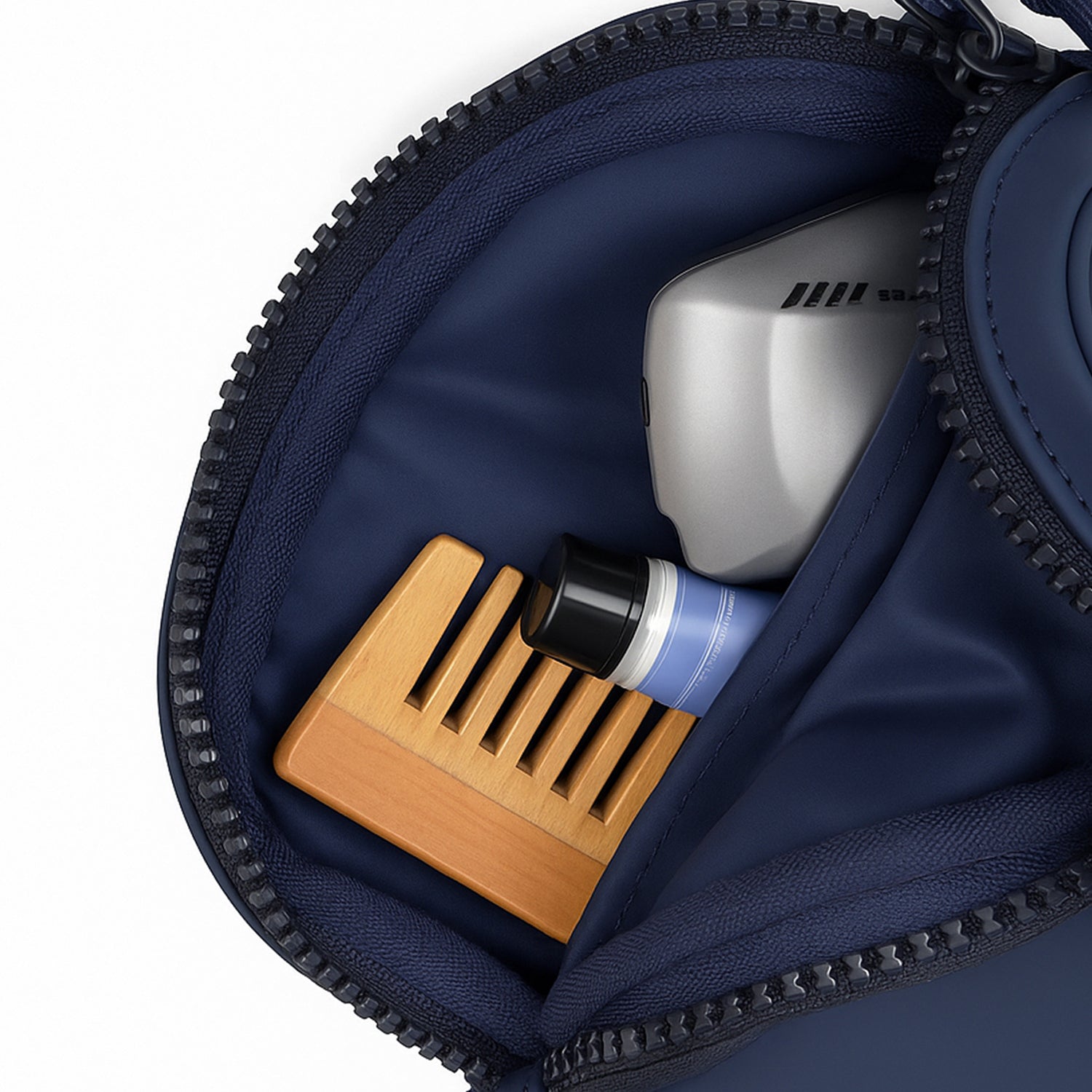Interior view of The Bloc Navy bag showcasing a wooden comb and grooming products neatly organized.