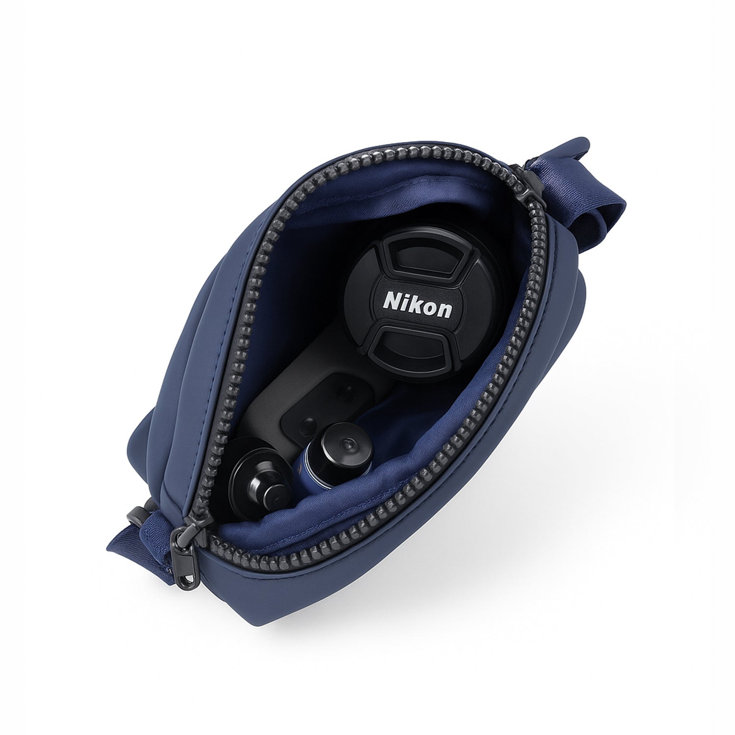 Open navy bag showing Nikon camera accessories including lens cap and buttons.