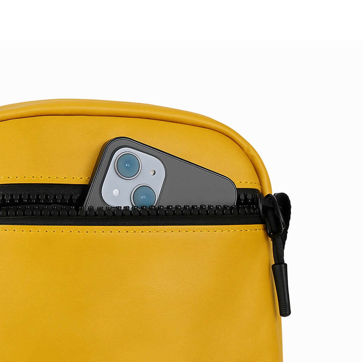 Close-up of a mustard bag zipper pocket with a smartphone partially visible, showcasing efficient organization.
