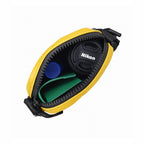 Interior view of THE BLOC mustard bag showing Nikon lens cap and accessories organized inside.