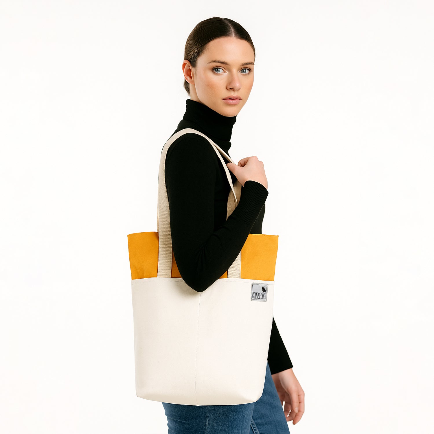 Model showcasing The Skylin off-white and yellow tote bag, featuring a spacious design and modern style.