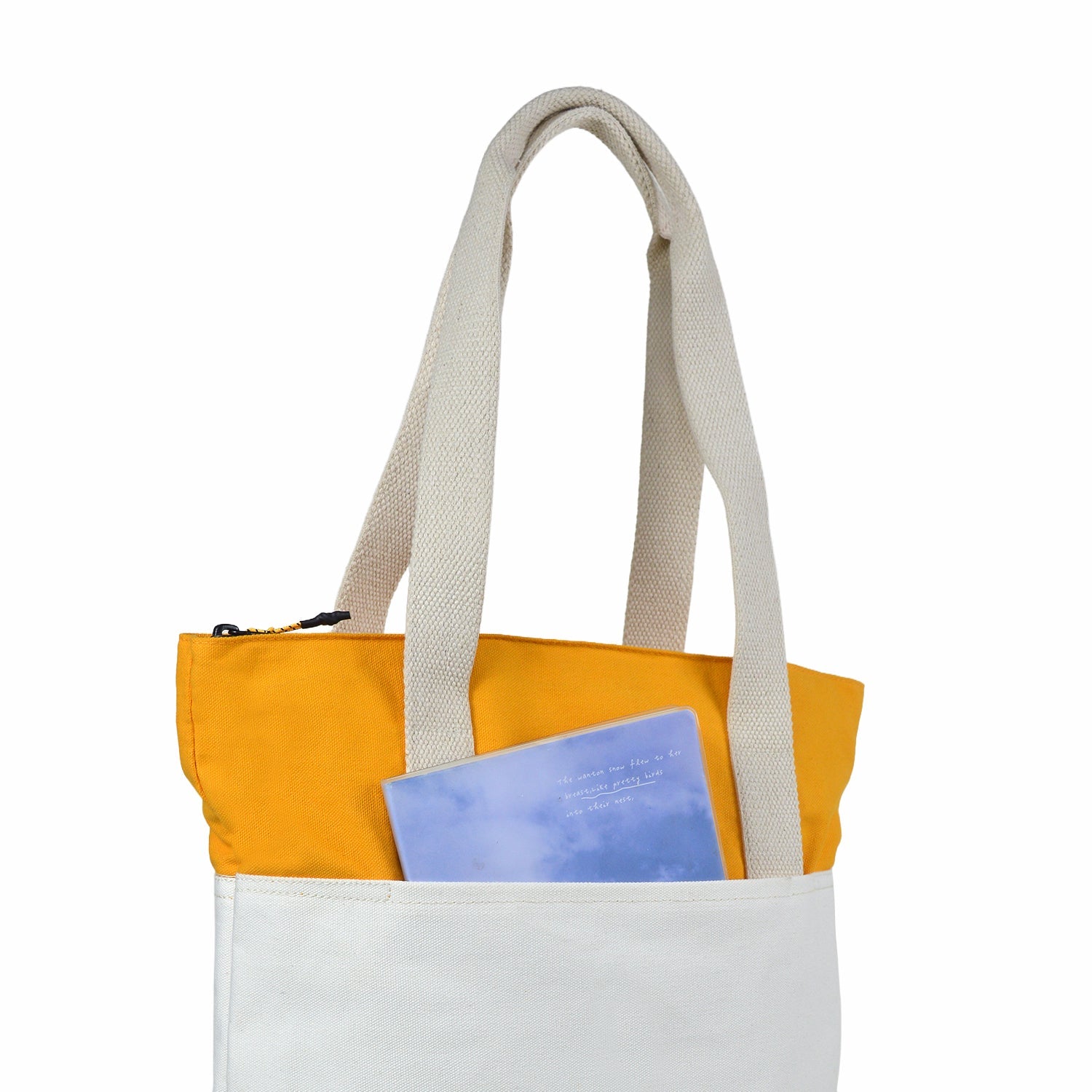 Offwhite and yellow canvas tote bag with a notebook in the front pocket, showcasing modern and versatile design.