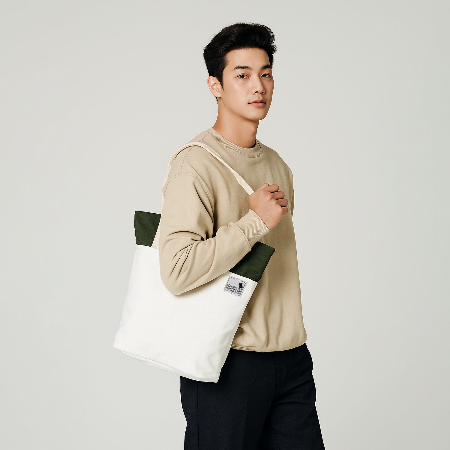 Model showcasing The Skylin tote bag in offwhite and army green, designed for modern functionality and style.