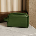 Chic green vegan leather toiletry kit on a marble surface, ideal for travel and daily organization.