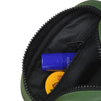Interior view of The Swift - Green toiletry kit showing organized toiletries in zippered compartment.