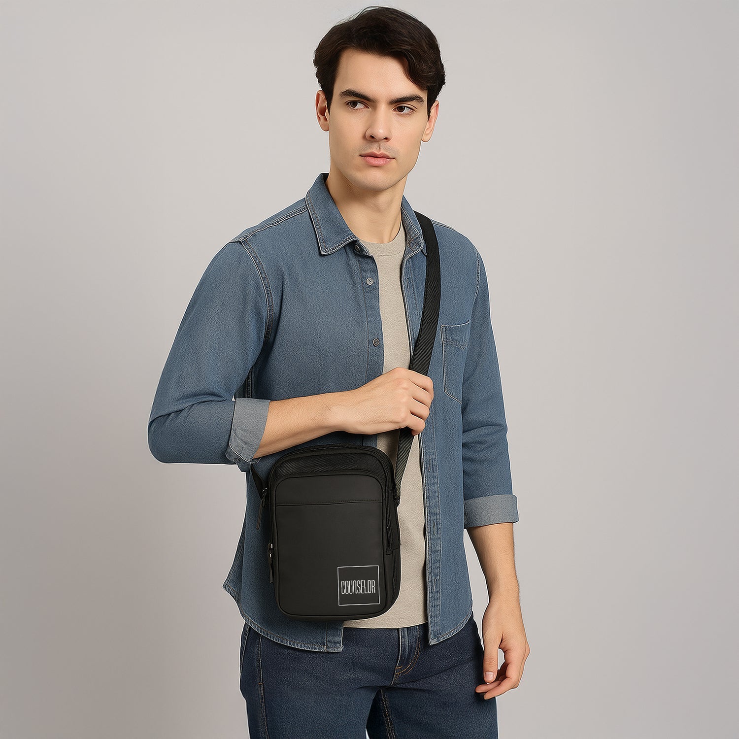Man wearing The Luno black sling bag, showcasing its stylish design and adjustable shoulder strap.