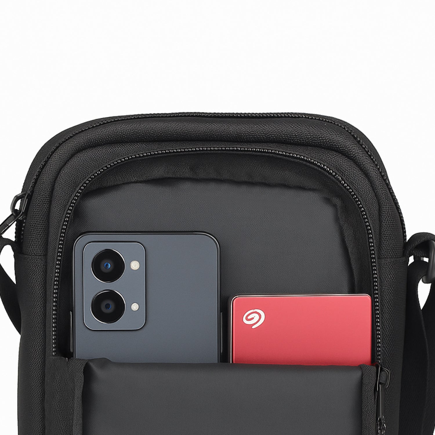 Close-up of the Luno Black Sling bag displaying phone and card in the front pocket, showcasing its smart organization design.
