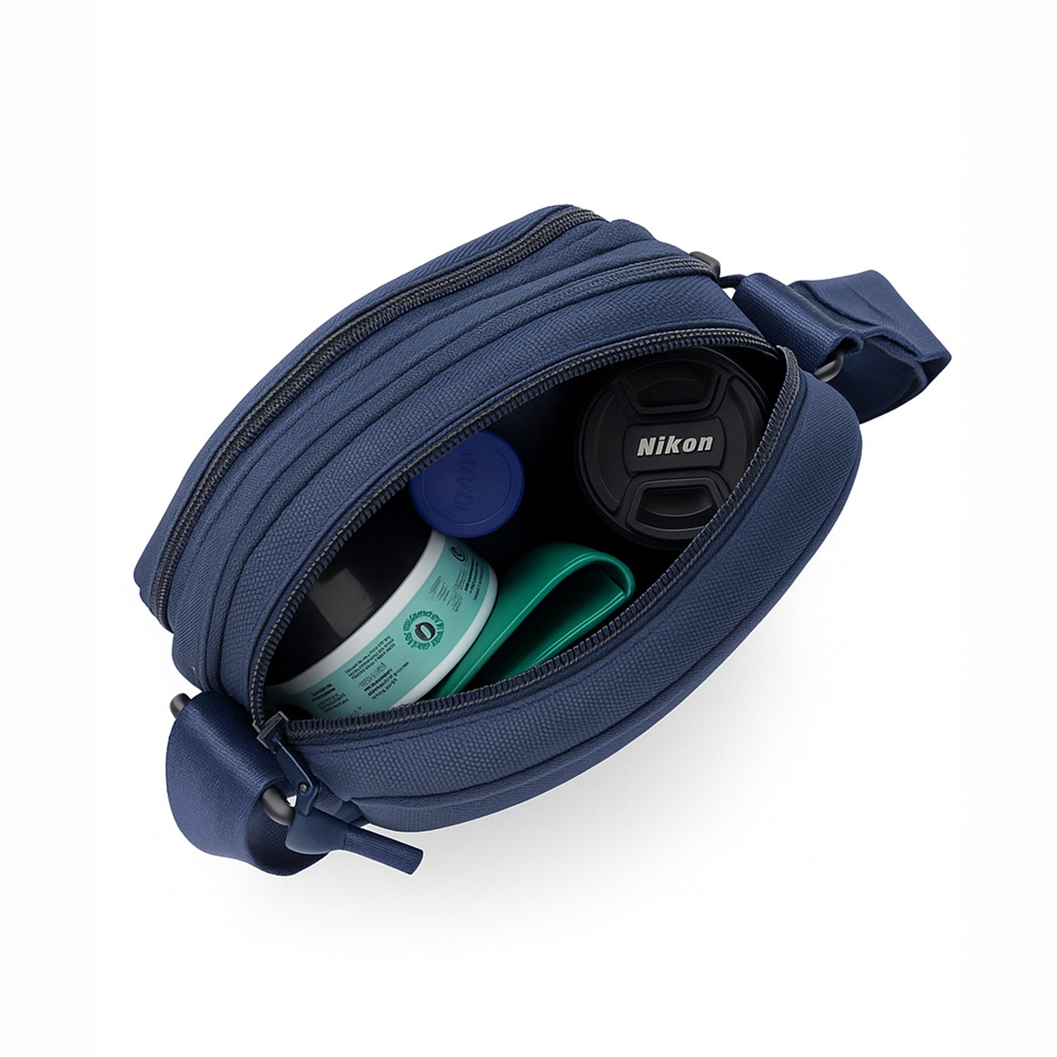 Inside view of the Luno navy blue sling bag, showcasing organized items like Nikon lenses and personal essentials.