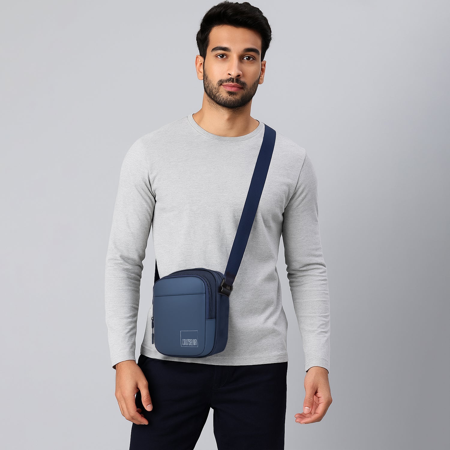 Stylish man wearing The Luno Navy Sling bag, showcasing its sleek design and adjustable strap.