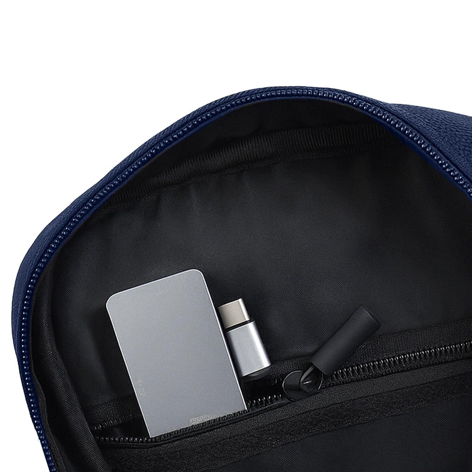 Interior view of the Luno Navy Sling bag showing organized pockets for essentials like a phone and wallet.