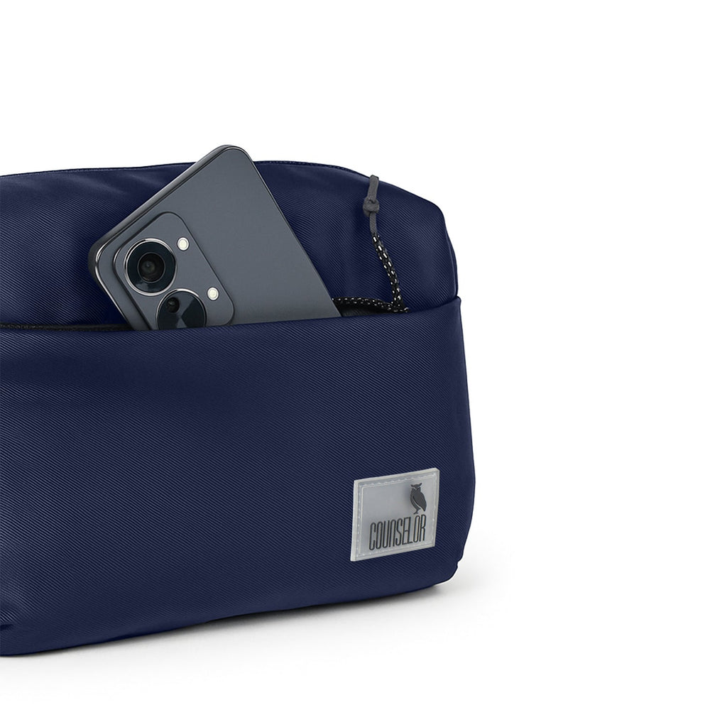 Navy The Avelin waistpack with smartphone in a pocket, showcasing smart storage and compact design for everyday use.