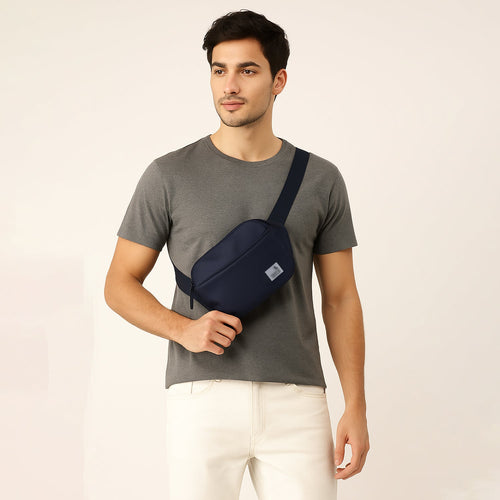 Stylish man wearing the Avelin navy waistpack, showcasing its minimalist design and versatile carrying options.