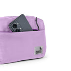 The Avelin waistpack in pink with a smartphone in the front pocket, showcasing its smart storage and compact design.