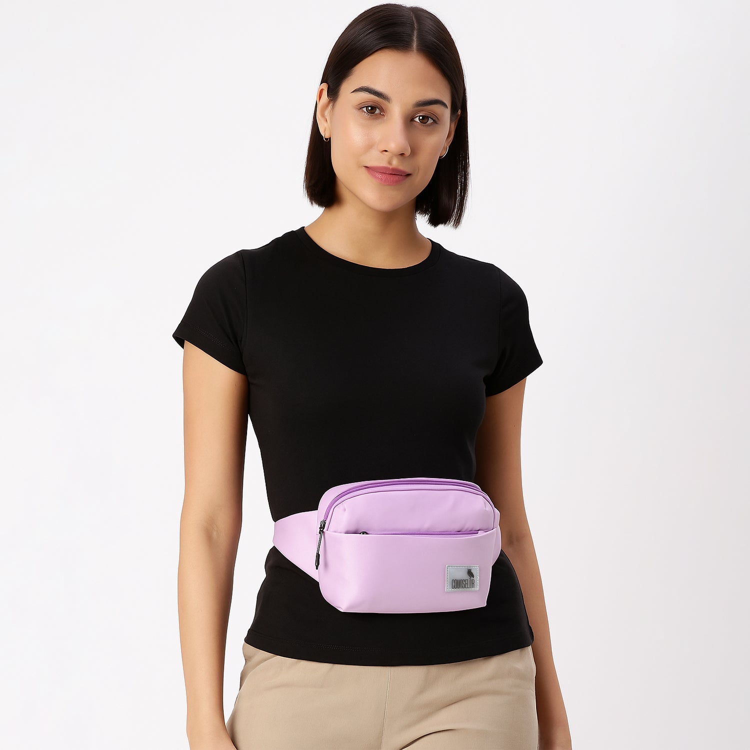 Woman wearing The Avelin pink waistpack, showcasing its minimalist design and adjustable strap for versatile styling.