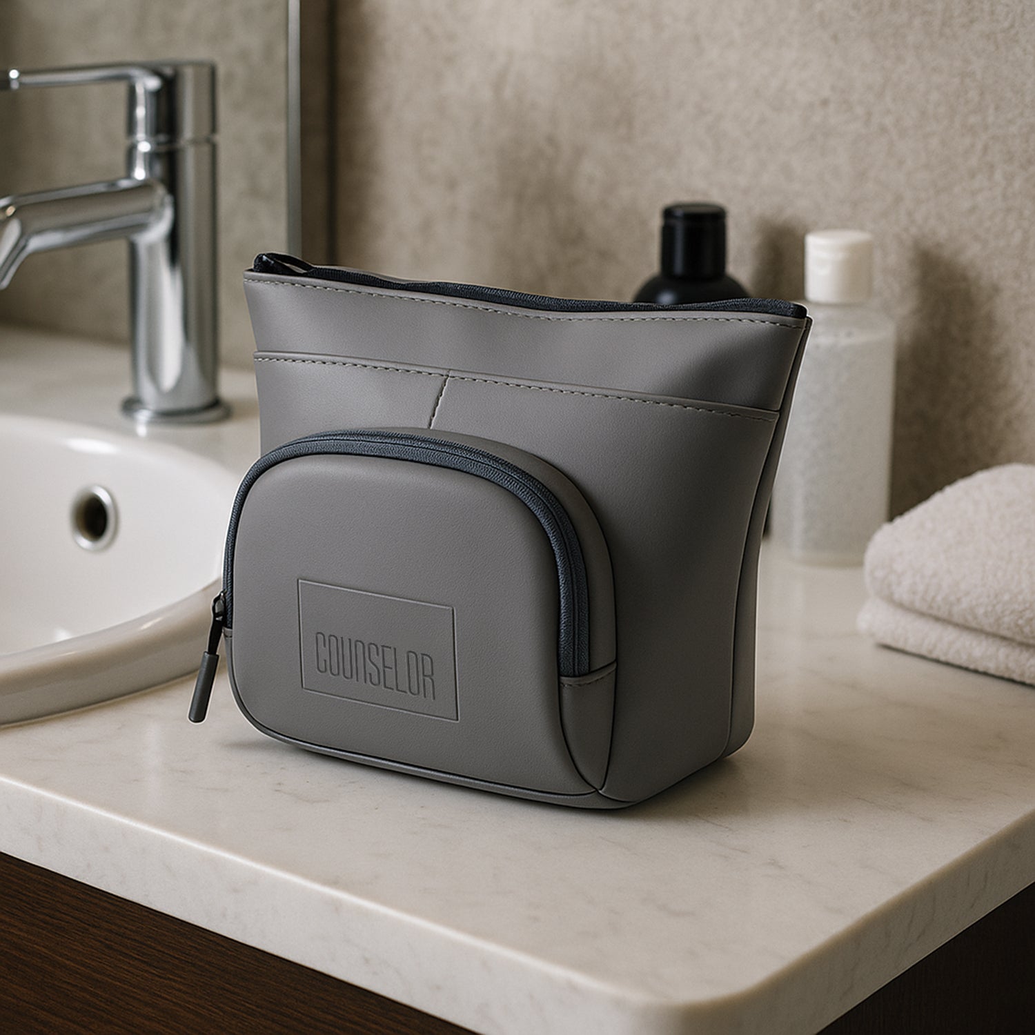 The Eiko grey pouch displayed on a bathroom counter, showcasing minimalist design and compact storage for essentials.