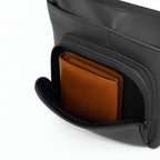 Interior of The Eiko black pouch showing a brown wallet in the zippered pocket for organized storage.