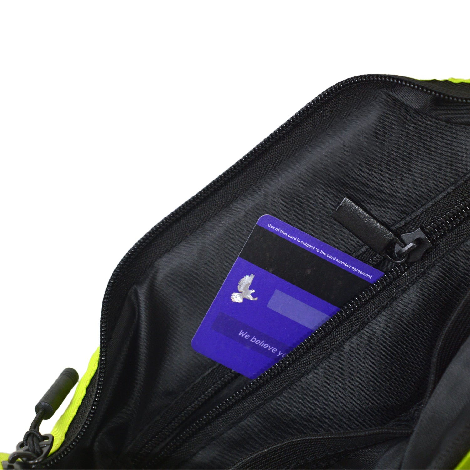 Interior view of the Zuki lime green sling bag showing an organized pocket with a credit card.