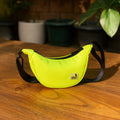 The Zuki lime green side sling bag on a wooden table, perfect for daily movement with sleek style and smart storage.