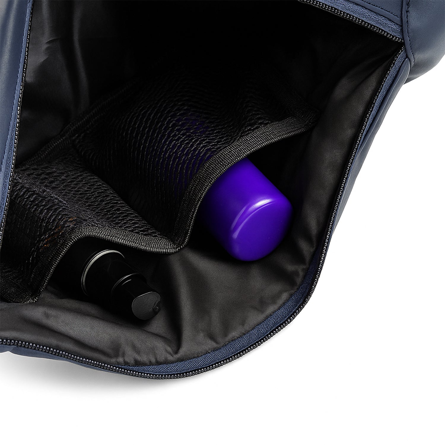 Interior view of The Zuki navy sling bag showing organized storage for essentials like bottles.