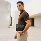 Man holding The Eiko black pouch with minimalist design, showcasing its chic and versatile style.