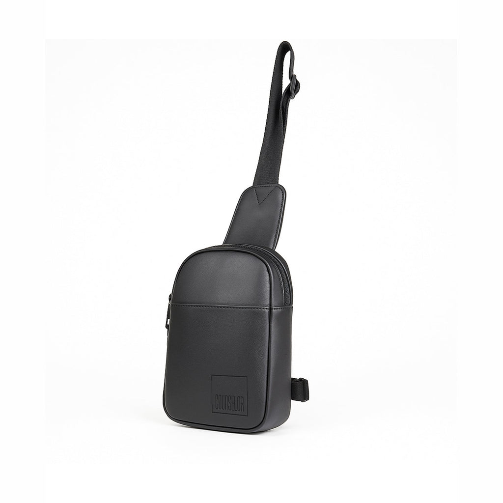 Stylish black crossbody bag made from vegan leather with adjustable strap and multiple compartments.