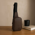 Kiro brown crossbody bag on wooden table, featuring stylish design and adjustable strap for comfort.