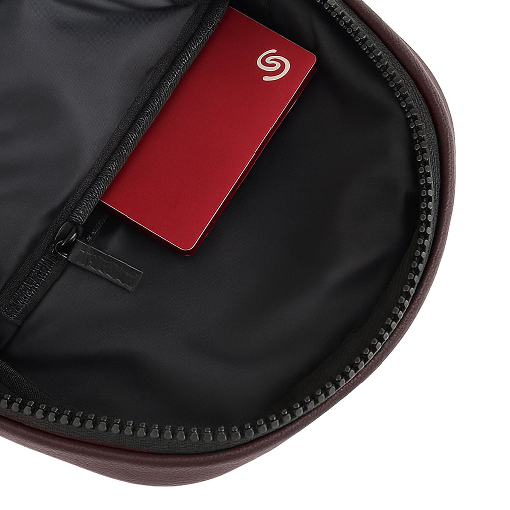 Interior view of the Kiro Crossbody Bag showing a zippered pocket with a card tucked inside.