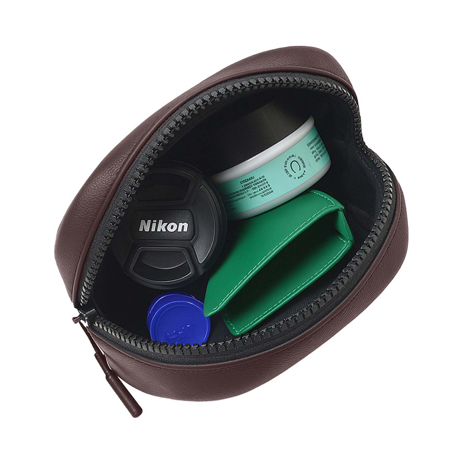 Brown Kiro Crossbody Bag interior showing Nikon lens cap, green wallet, and cosmetic container.