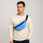 Man wearing a sky blue Nexo waist pouch over a beige sweatshirt, showcasing a stylish and practical design.
