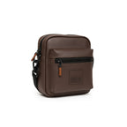 Stylish brown Noma bag made of vegan leather, featuring adjustable strap and front zipper pocket for convenience.
