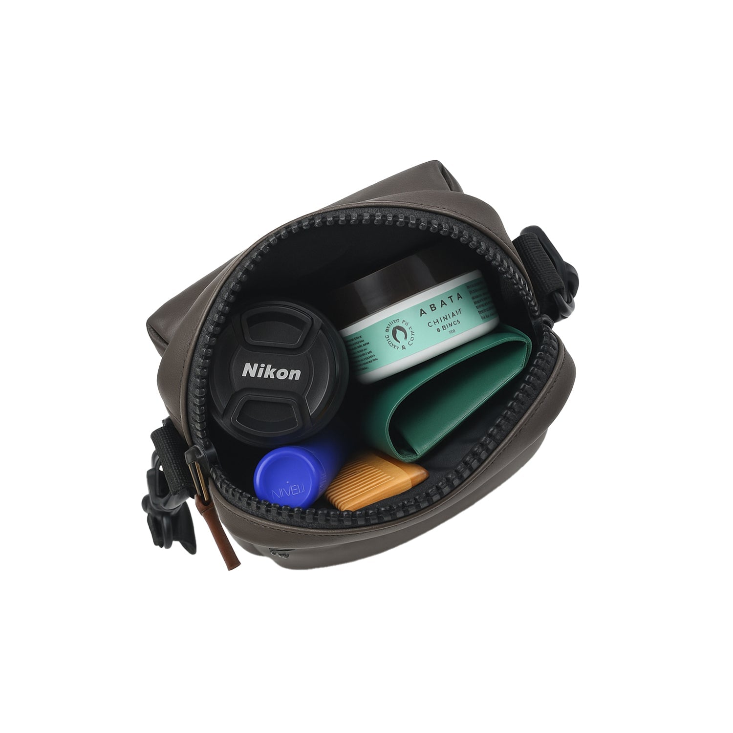 Compact bag showing organized compartments with camera lens, skincare products and other essentials.