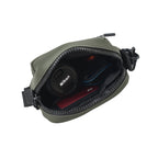 Interior view of THE NOMA - OLIVE bag showing Nikon lens cap and other essentials neatly organized.