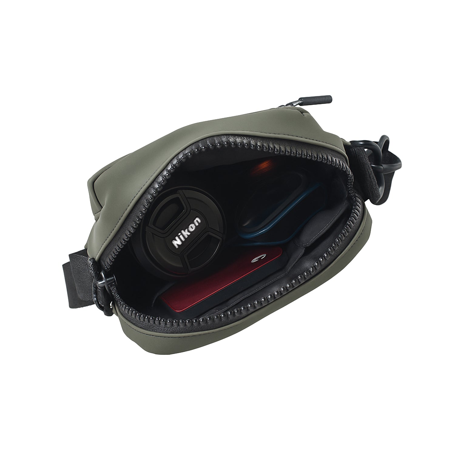 Interior view of THE NOMA - OLIVE bag showing Nikon lens cap and other essentials neatly organized.